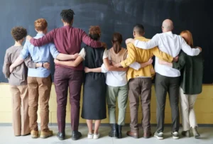 Gruppe von Internationalen Menschen die sich in der Reihe im Arm halten und unterstützen